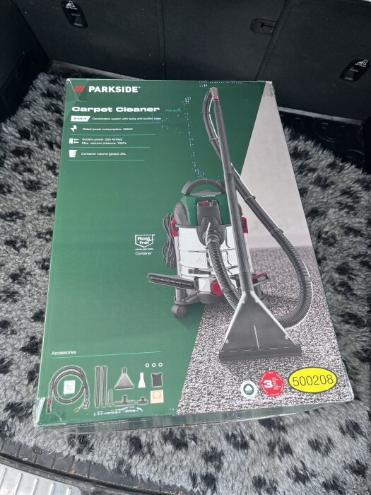 Parkside mattrengörare i kartong, fotad i en bil. Produkten är grön och vit med svarta och röda accenter.