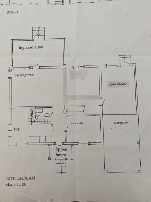 Planlösning av bottenvåning med vardagsrum, två sovrum, kök, WC, inglasad altan, carport och öppen farstu i skala 1:100.