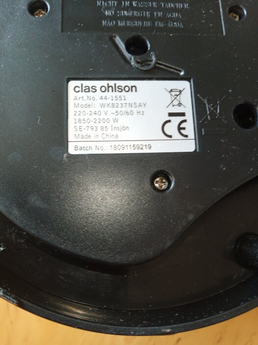 Bild på undersidan av en elektrisk apparat med produktetikett från Clas Ohlson, med specifikationer såsom modellnummer och tillverkningsland.