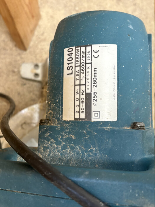 Märkskylt på en blå kapsåg, modell LS1040, med tekniska specifikationer som 1650W och 255-260mm klinga.