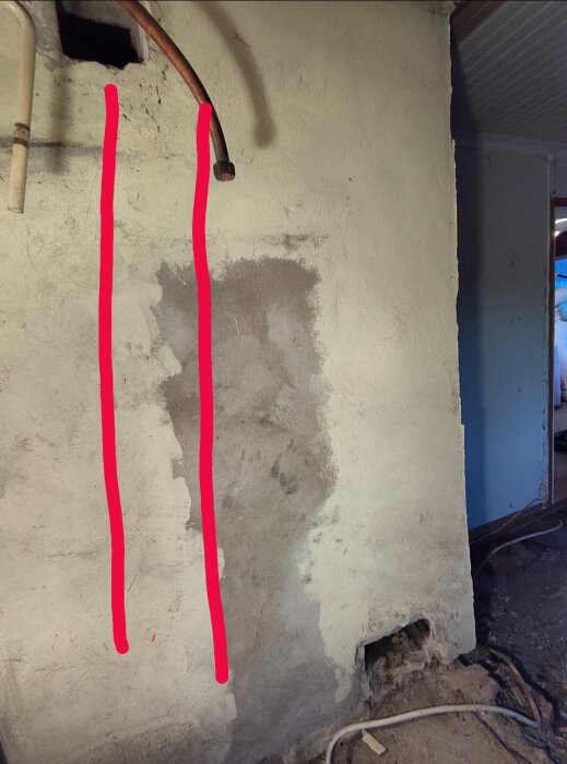 Vägg med två pipor, en röd markerad linje visar planerat kapningsområde för förlängning av murmepipa under renovering.