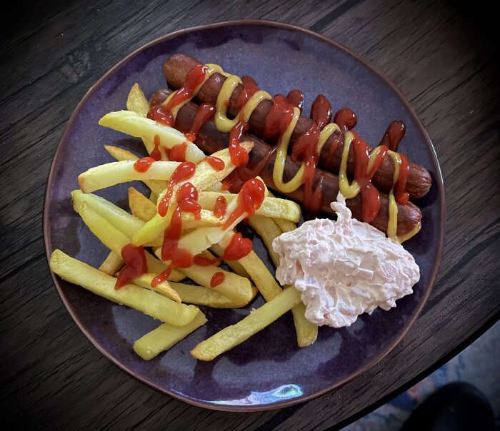 Tallrik med korv och pommes frites toppade med ketchup och senap, samt en klick räksallad.