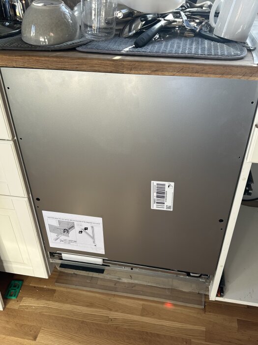 Diskmaskin Asko DFI5554MMXXL utan frontpanel, med verktyg och instruktioner på övre bänken i köket.