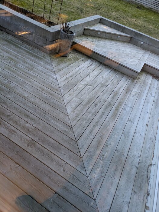 Träaltan i trädgård med trappsteg och betongplantering, fotograferad från en högre vinkel.