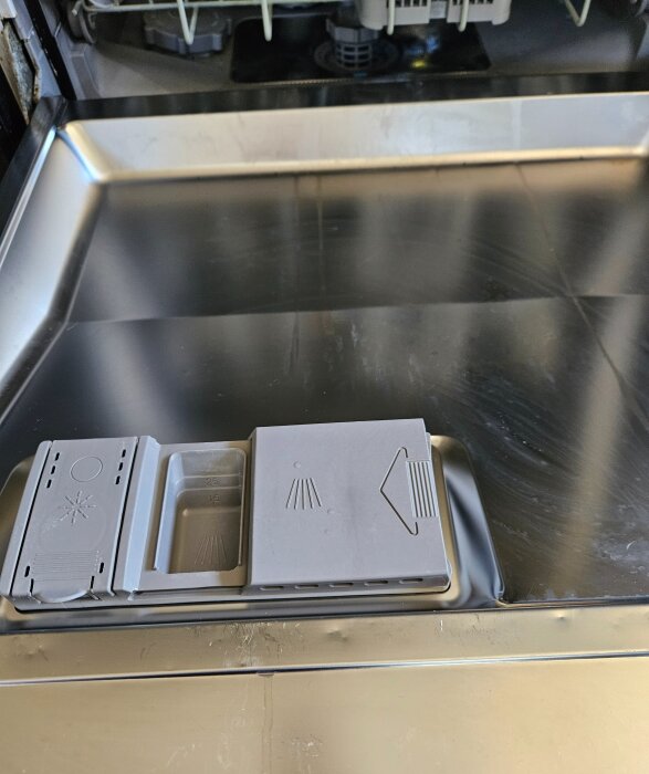 Diskmaskin från Bosch med två rengöringsfilter och en behållare för diskmedel, fotograferad inuti maskinen.