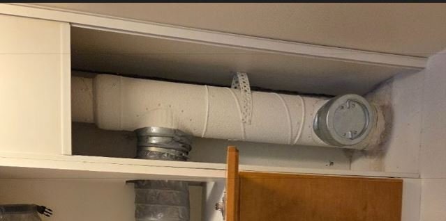Rörledning med isolering i ett skåp, med en ventilationskoppling ansluten.