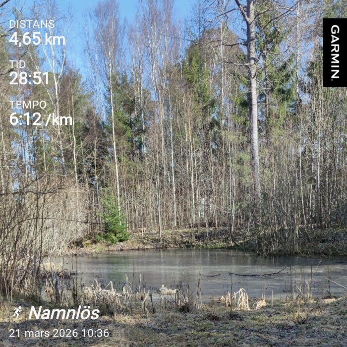 Isbelagd damm med omgivande träd och växtlighet, text visar löprunda detaljer: distans 4,65 km, tid 28:51, tempo 6:12/km, datum 21 mars 2026.