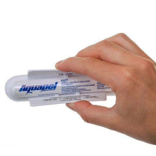 Hand håller i en tub Aquapel-produkt för bilvård.