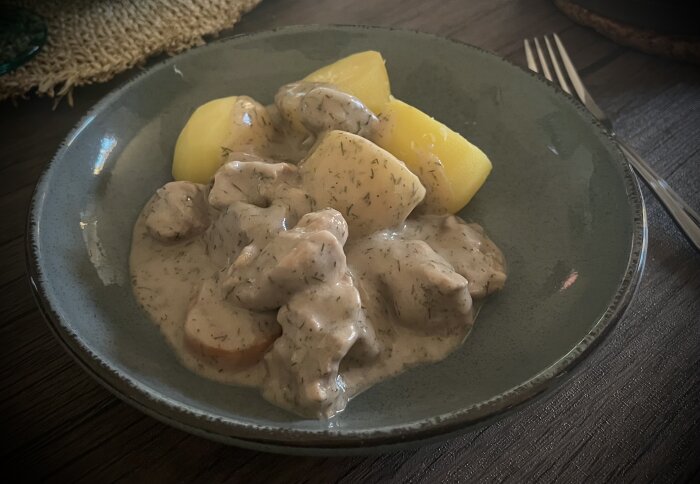 Dillkött av kalvhögrev med dillgräddsås serverat med kokt potatis på en tallrik.