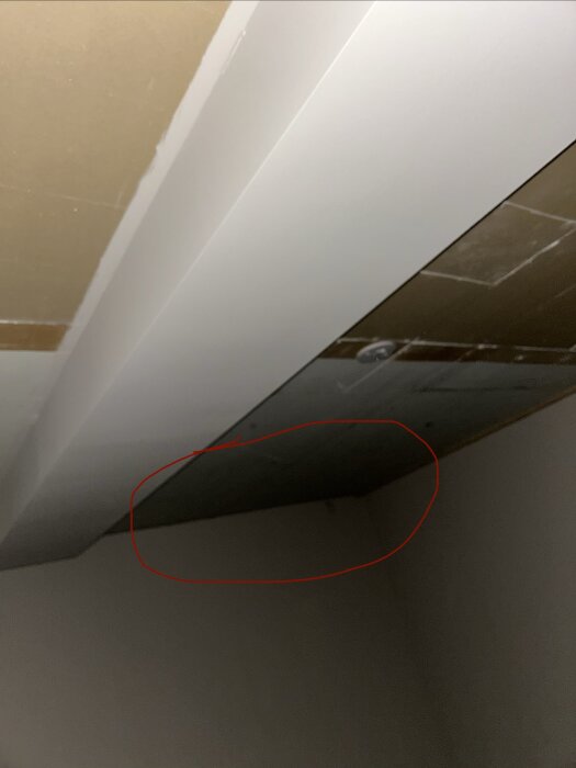 Öppet tak med en röd cirkel som markerar saknade reglar under ett gammalt tak i ett byggprojekt för garage och förråd.