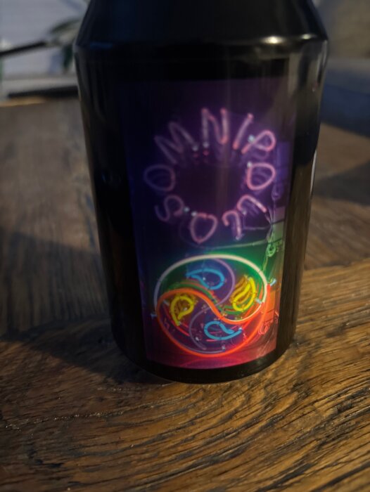 Flaska Omnipollo Tokyo med färgglad etikett på träbord.