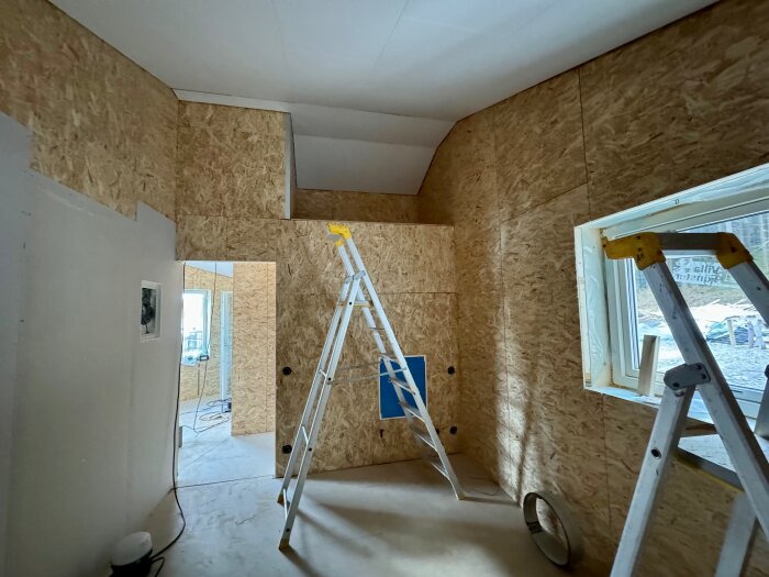 Renoveringsspåntak med stege och fönster; gipsat och klart för kommande golvläggning.