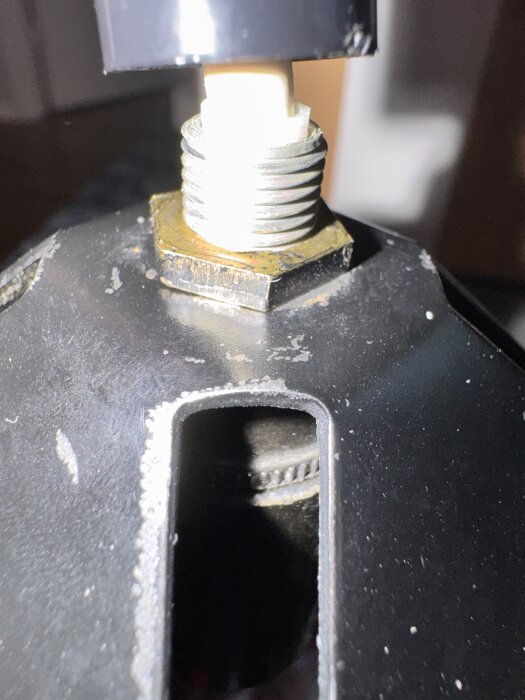 Närbild av en skruvad av del som visar plast och en extra lager plast innanför metallen.