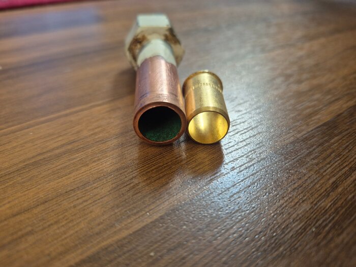 Kopparrör bredvid en stödhylsa på ett träbord, i samband med ett inlägg om installation av ballofix och tjockleken på kopparrören.