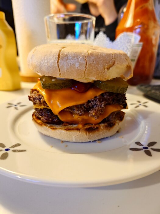 Smashburgare med ost, pickles och ketchup pÄ en tallrik.