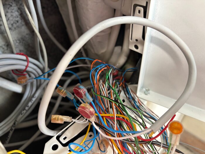 Kablar med olika färger och skarvklämmor i en kopplingsbox för KNX-buss, potentiell glappkontakt identifierad i ett kabelnystan.