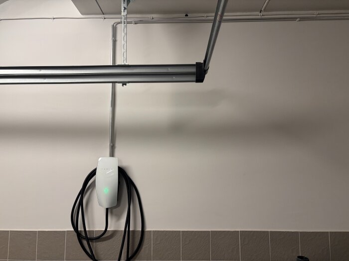 Laddbox monterad i ett garage, ansluten med aluminiumrör i överkant, utan signalkabel för konstant full laddning.