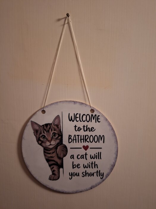 Välkomstskylt till badrummet med en katt och texten "Welcome to the bathroom, a cat will be with you shortly".