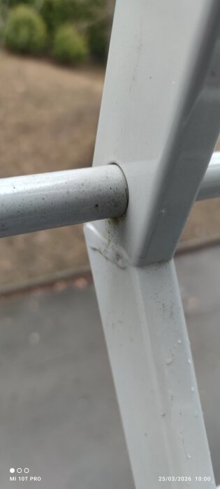 Närbild på svetsfog i ett balkongräcke med ojämn utföring, viss missfärgning synlig på metallen.