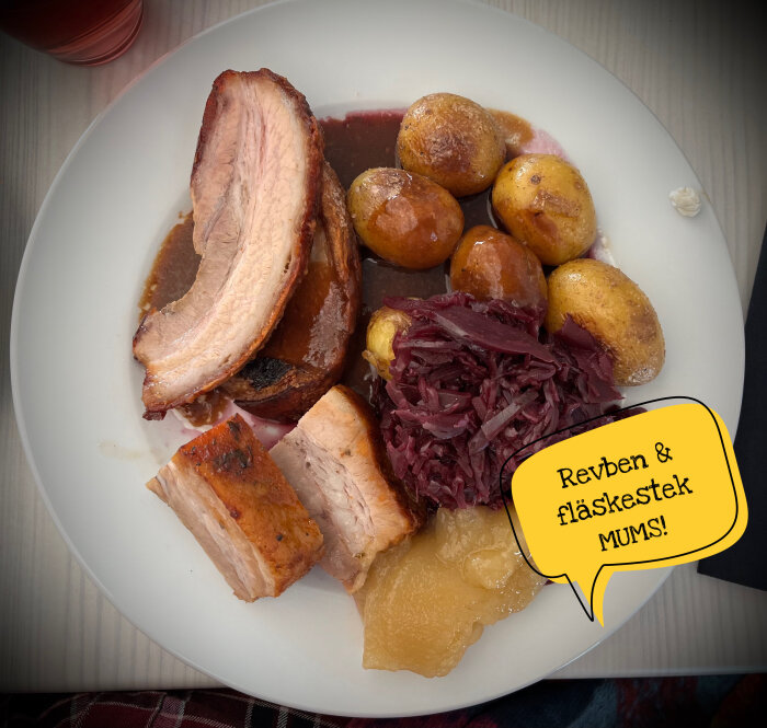 Tallrik med revben, fläskstek, små potatisar, rödkål och äppelmos. Text i pratbubbla: "Revben & fläskestek MUMS!".