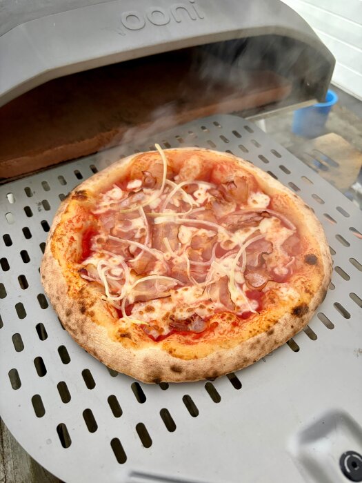 Pizza tillagas i en Ooni-pizzaugn, redo att serveras.
