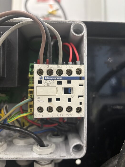 Närbild av en kopplingsbox med kablar anslutna till en kontaktor, märkt "Telemecanique LC1K09". Flera ledningar och anslutningspunkter syns.