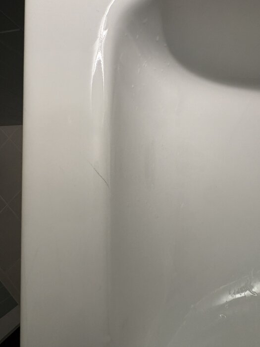 Porslinstvättställ med synliga repor efter renovering.