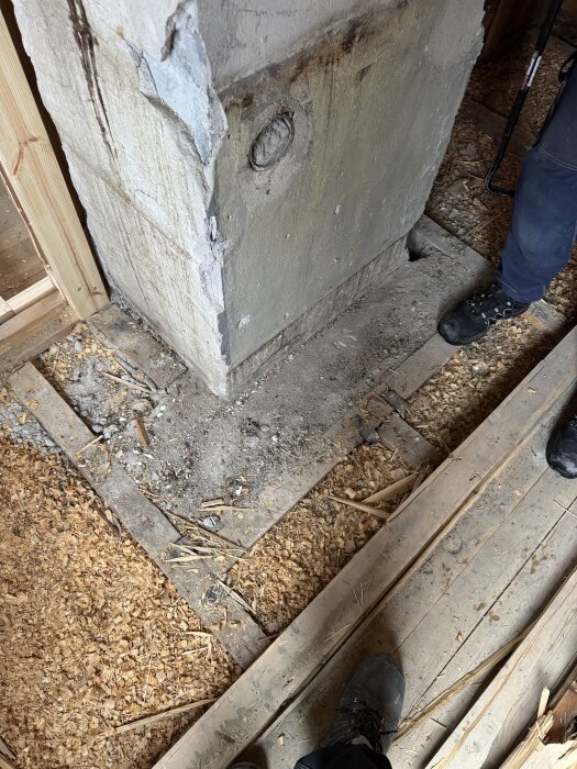 Betong och cement mellan reglar vid en skorsten i ett hus från 1929, med fråga om dess ändamål och möjligheten att ersätta med regelverk.