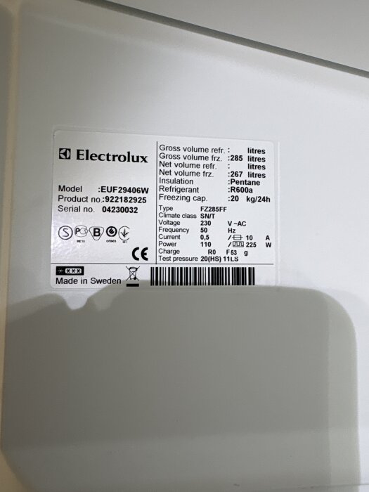 Etikett på en Electrolux frys med modellnummer EUF29406W, serier 04230032, spänning 230V, miljömärkt och "Made in Sweden".