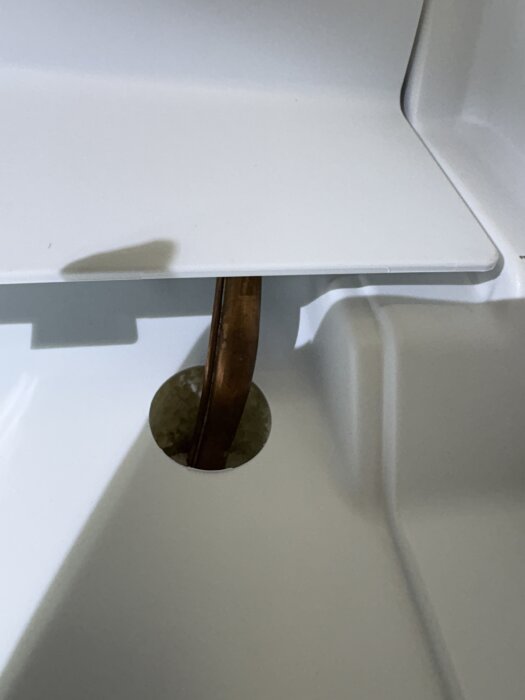 Inuti en Electrolux frys syns ett kopparrör som sticker genom en öppning i plastpanelen. Runt röret syns förhöjning av plasten.