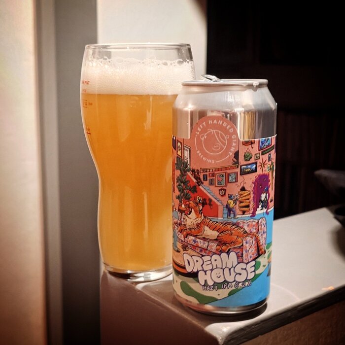 En ölburk med namnet "Dream House" bredvid ett glas fyllt med ljus öl, skapat av Left Handed Giant Brewing.