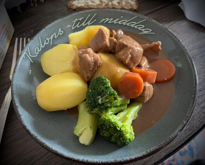 Kalops med brunsås, kokt potatis, broccoli och morötter på en tallrik.