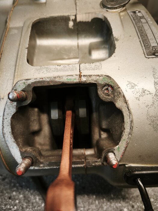 Verktyg som används för att borra ur en M6-bult i aluminium, visar en kombination av metalldelar och skruvar i ett mekaniskt sammanhang.