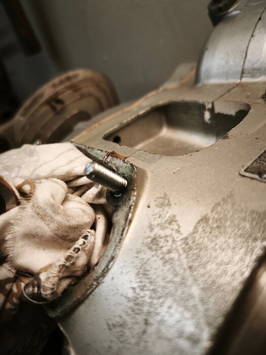 Borrad aluminiumdel med tygbit och en M6-bult synlig, resultat av renoveringsarbete.