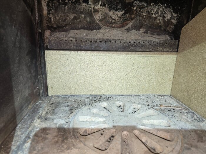 Nyskurena plattor monterade i en ugn eller kamin med en rund, perforerad plåt på botten, redo för borrning av hål.