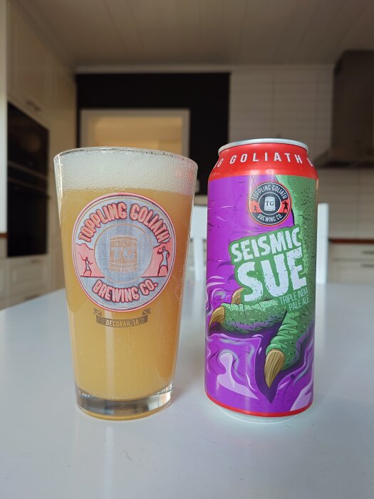 Ett glas öl bredvid en burk med etiketten "Seismic Sue" i ett modernt kök.
