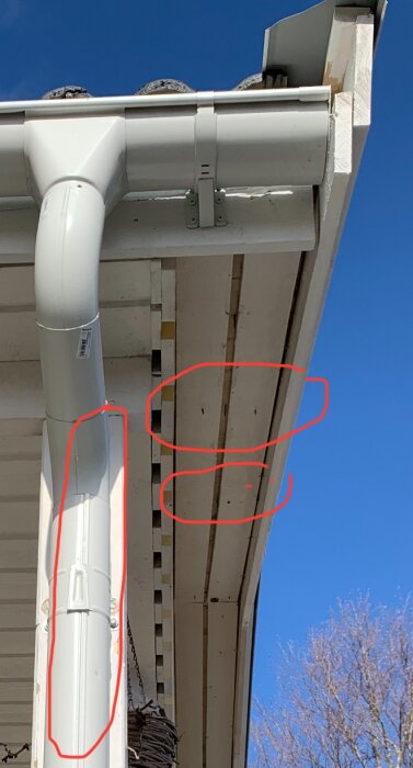 Nyinstallerade vindskivor och hängränna med otydliga brister markerade i bilden. Soligt väder och blå himmel.