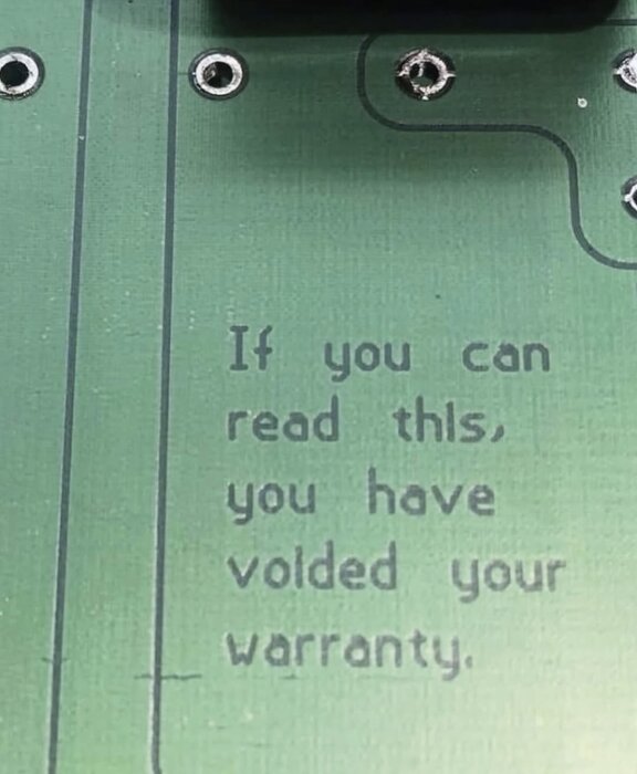 Text på ett kretskort: "If you can read this, you have voided your warranty.