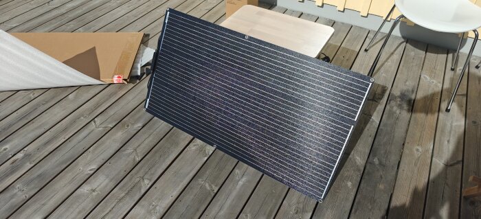 Solpanel på trätrall med kartong bredvid.