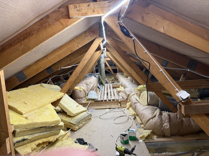 Ljusslinga installerad på vinden med träbjälkar och isolering.