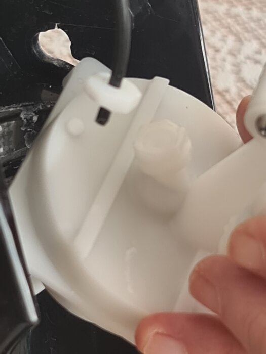 Trasig slangkoppling i en kolsyremaskin, närbild av kopplingen med plastdelar och kabel i fokus.
