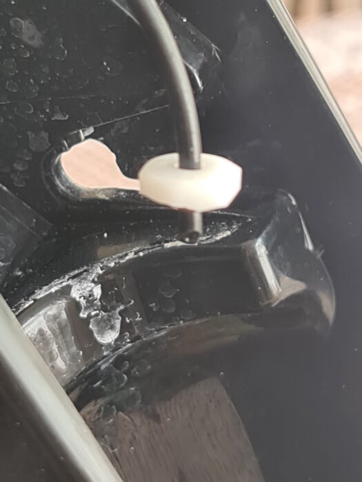 Trasig slangkoppling i en kolsyremaskin, med en plastdetalj och slang synliga inuti enheten.