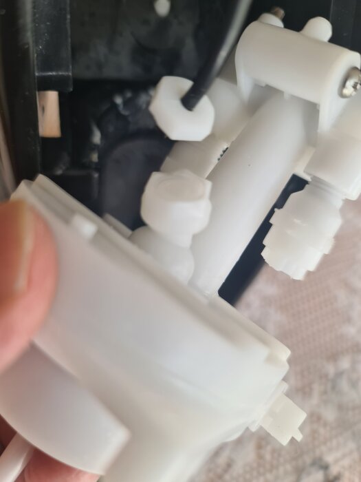 Trasig slangkoppling i en kolsyremaskin med vit plastkomponent synlig på nära håll.