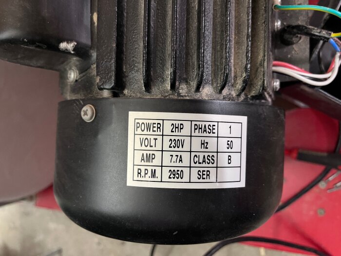 Etikett på spånsugs motor, visar specifikationer: 2HP, 230V, 7.7A, 2950 RPM, fas 1.