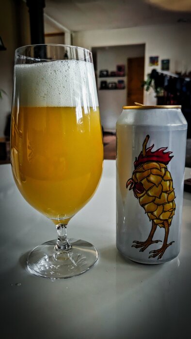 Glas med öl och en ölburk med en illustration av en humlekotte med tuppkam, märkt "Hoppy Holiday" från Fermenterarna.