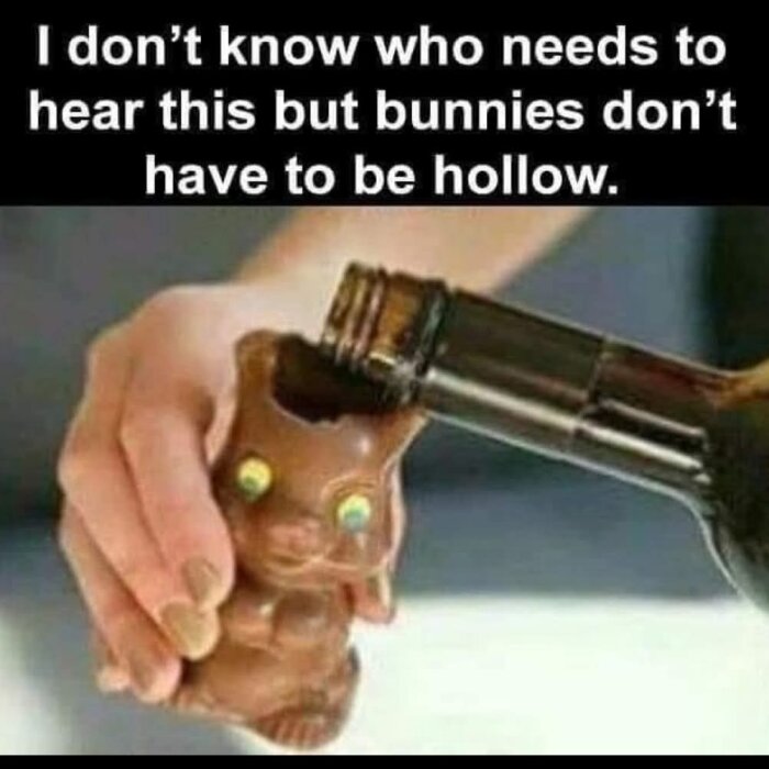 Hand håller en ihålig chokladkanin och häller vin från en flaska i den, med texten "I don't know who needs to hear this but bunnies don't have to be hollow.