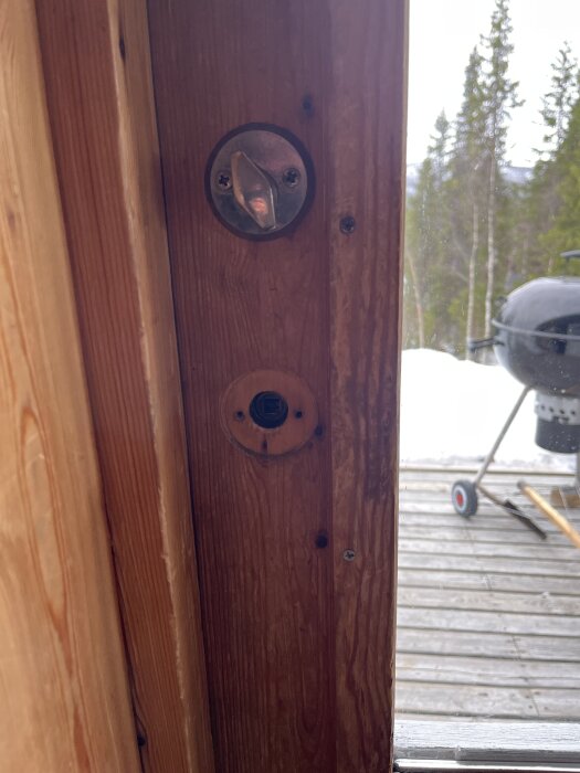 Dörrkarm utan synliga hål för genomgående skruv; äldre låshus synligt.