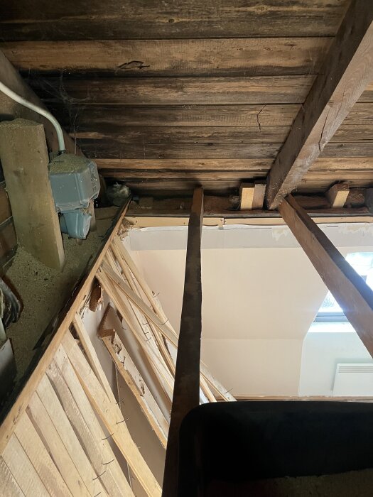 Inre tak med synliga reglar och takstolar, inklusive snedställda reglar som kan utgöra en strukturell del av ett mansardtak.