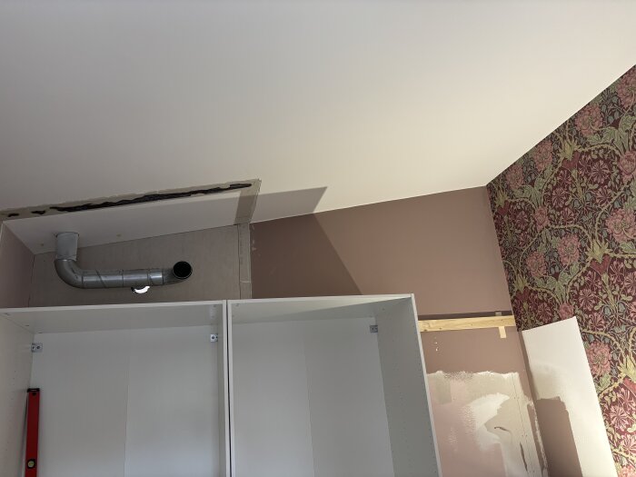 Övergarderober med ventilation, rosa vägg och blommig tapet i sovrummet. IKEA Pax-stommar används i bygget.
