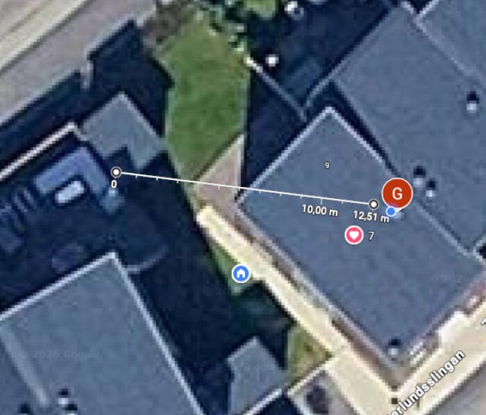 Satellitbild från byggområde med hustak, gräsmatta och gångväg. Mätlinje på 12,51 m visas.